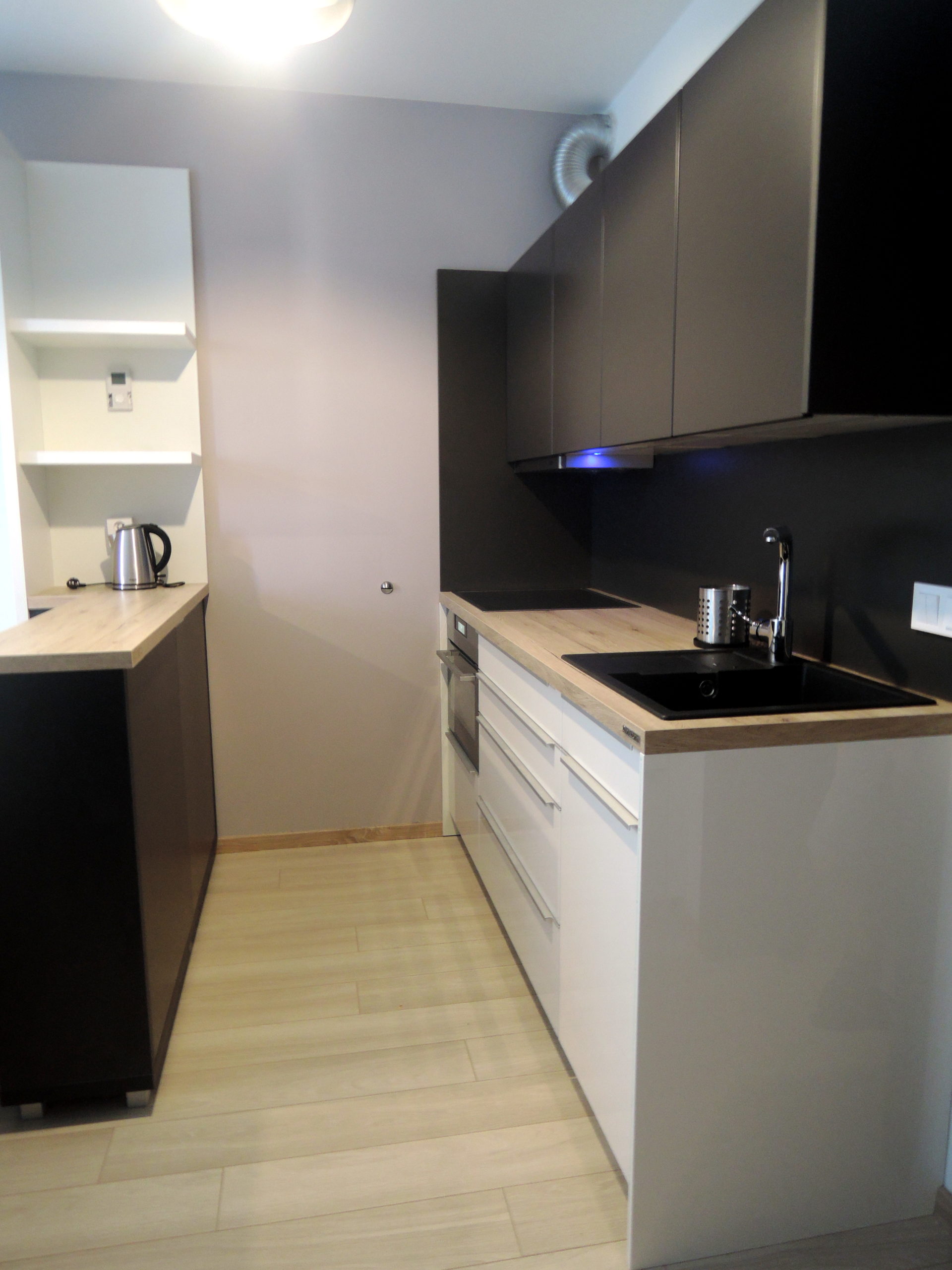 moderná obývačka s kuchyňou, malý byt interiér, minimalistický dizajn, sivá sedačka, otvorený priestor