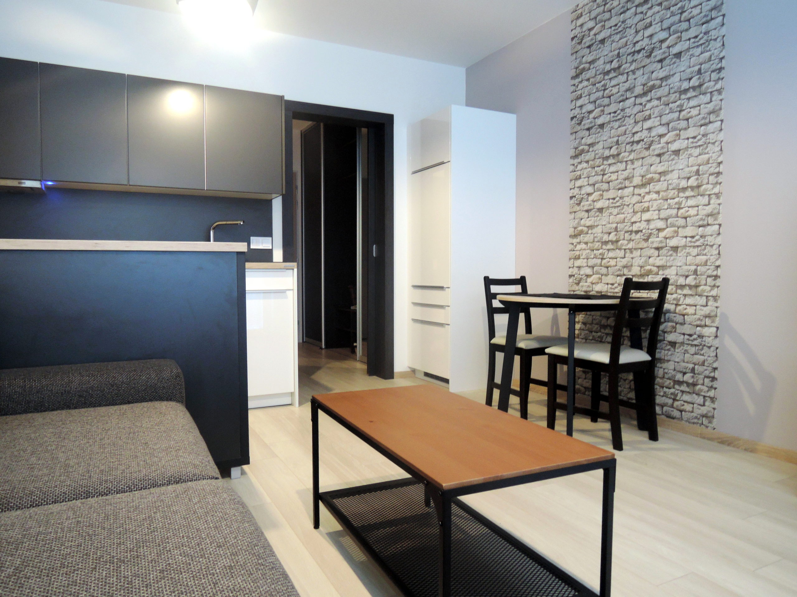 obývačka s jedálenským stolom, dekoratívna tehlová stena, moderný interiér bytu